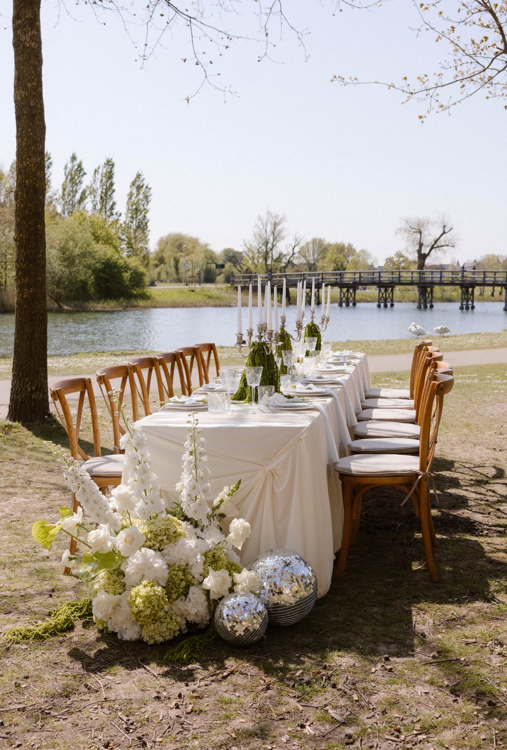 Gedekte trouwtafel aan het water met bloemen