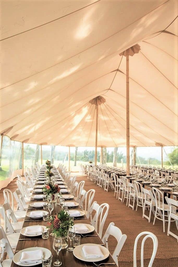 Lange gedekte tafels in een sailcloth tent
